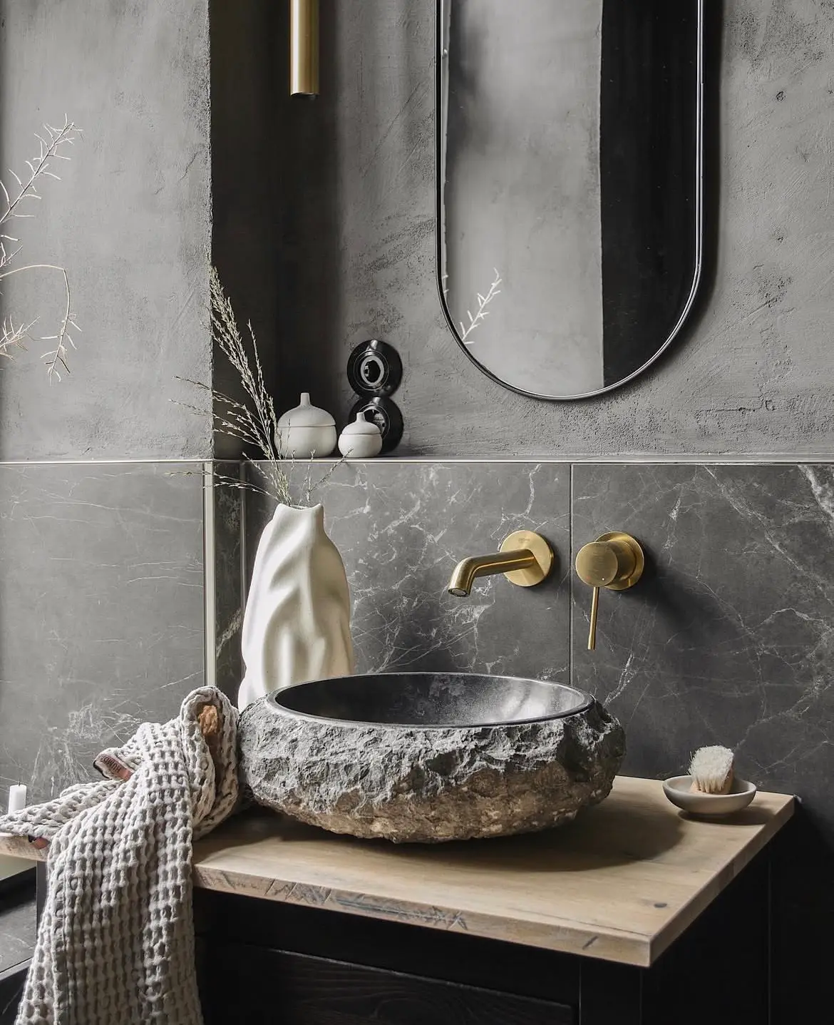 Baie renovată cu lavoar din piatră și baterie aurie